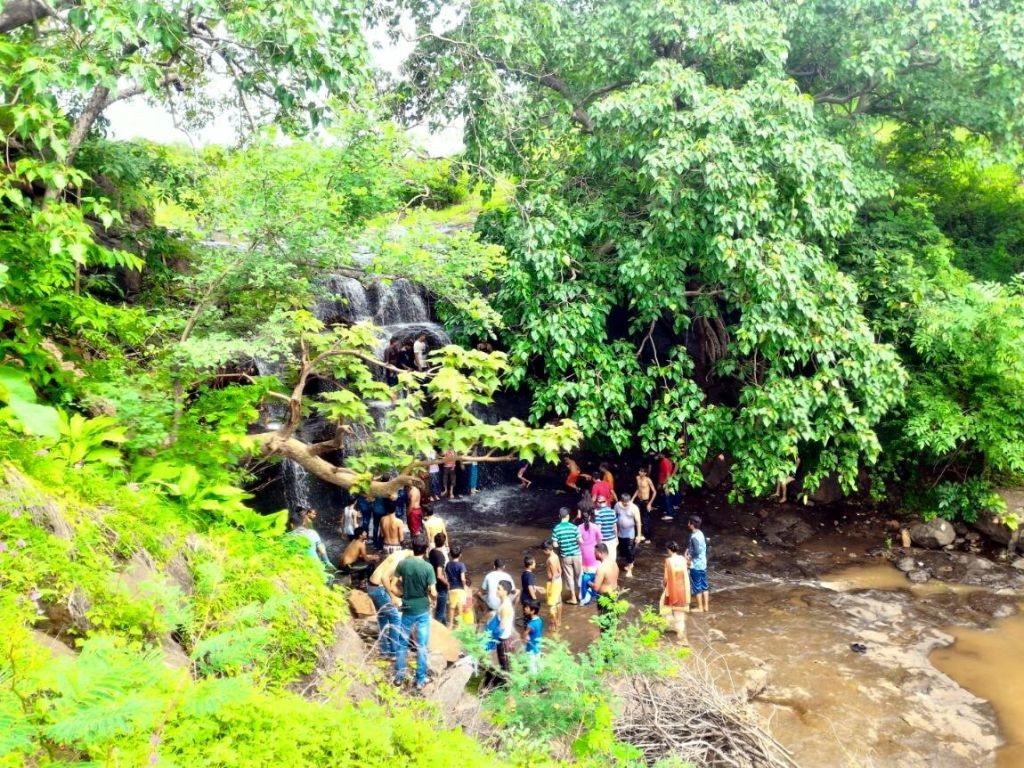 Tourists enjoying shower under dhodh Bilpudi Jodiya Waterfalls Dharampur